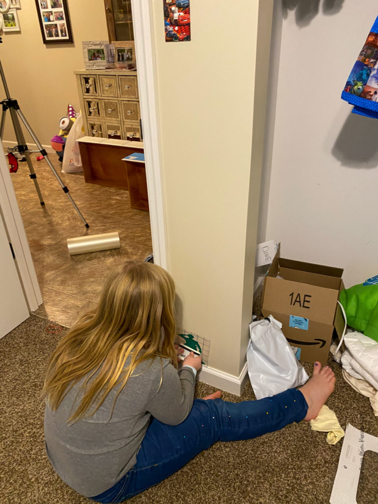 girl applying vinyl decal to wall