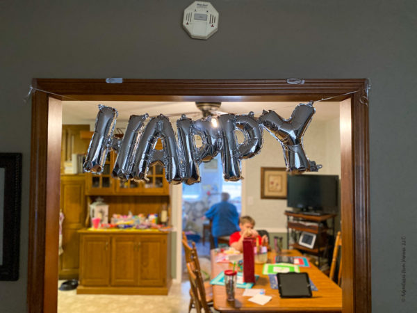 happy balloon spelled out in silver