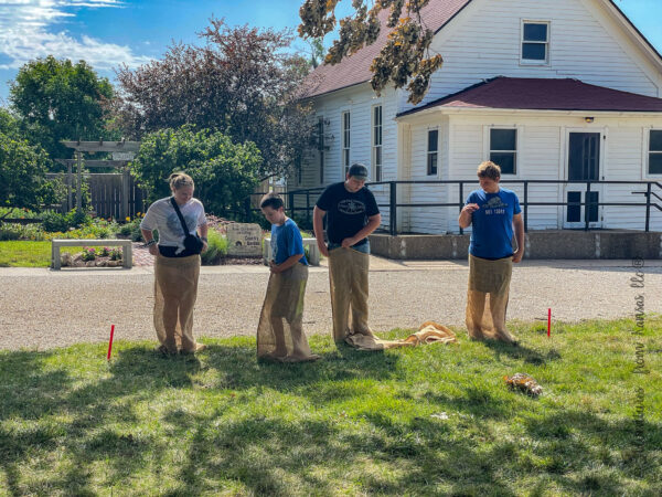 4 kids doing potato sack race at shawnee town 1929 in shawnee, Kansas, Johnson country
